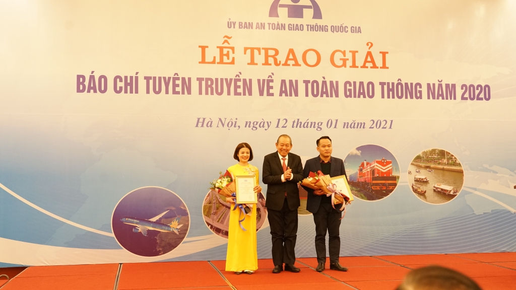 Đồng chí Trương Hòa Bình - Ủy viên Bộ Chính trị, Phó Thủ tướng Thường trực Chính phủ, Chủ tịch Ủy ban ATGT quốc gia trao giải Nhất tới phóng viên Nguyễn Thị Hạnh (báo Tuổi trẻ Thủ đô) và đại diện nhóm tác giả báo Giao thông